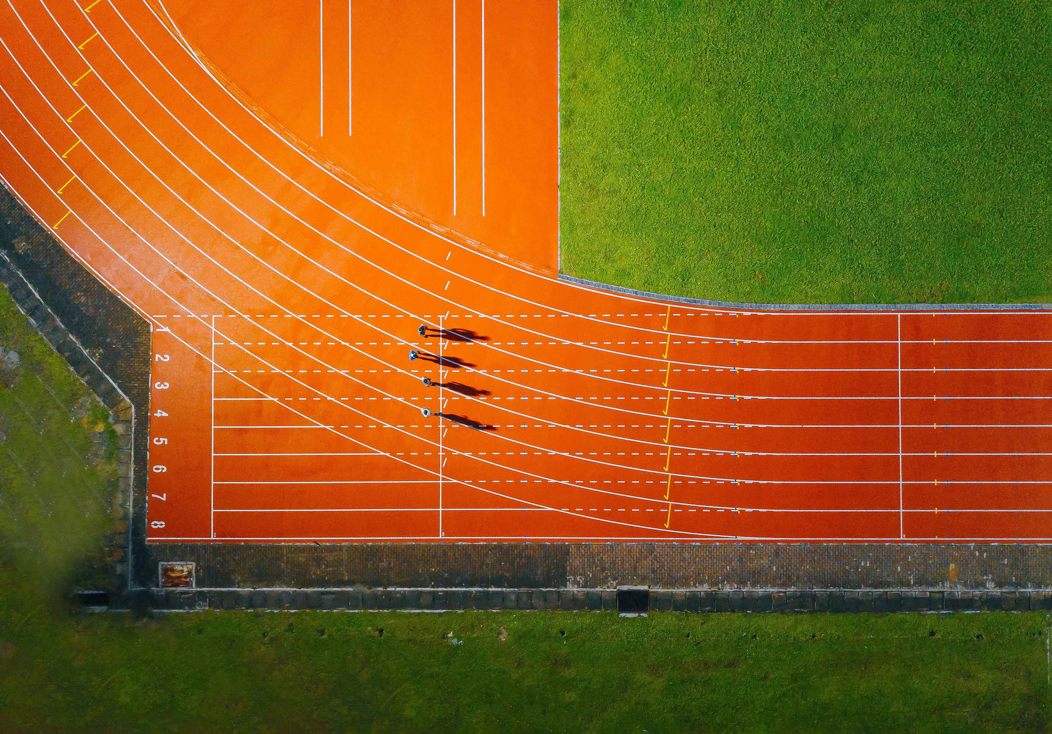directly above drone point of view asian chinese male athlete running at men's track rainy late evening in stadium