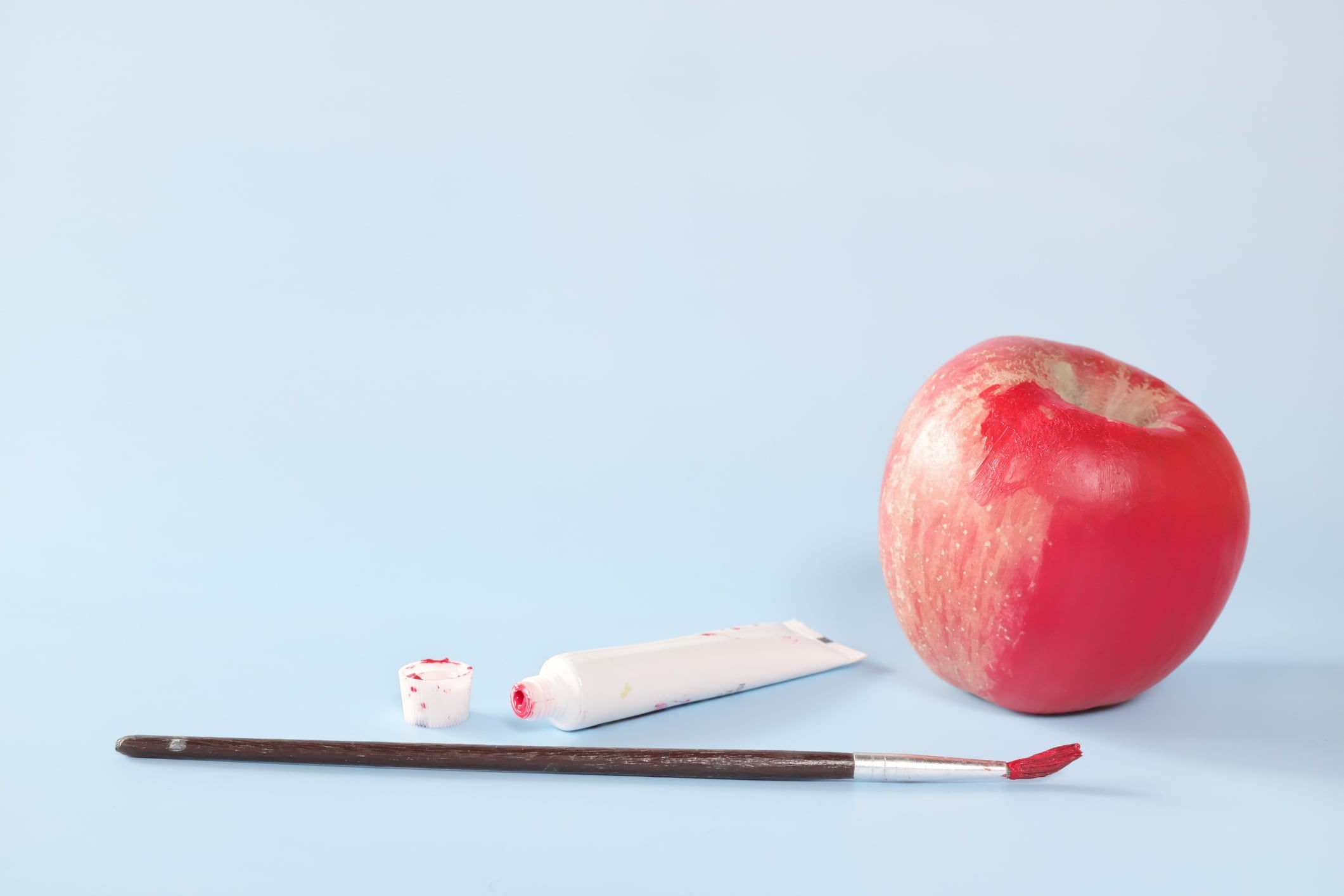 Fake food, colouring, fraud and fraudulent food concept. Apple painted red.