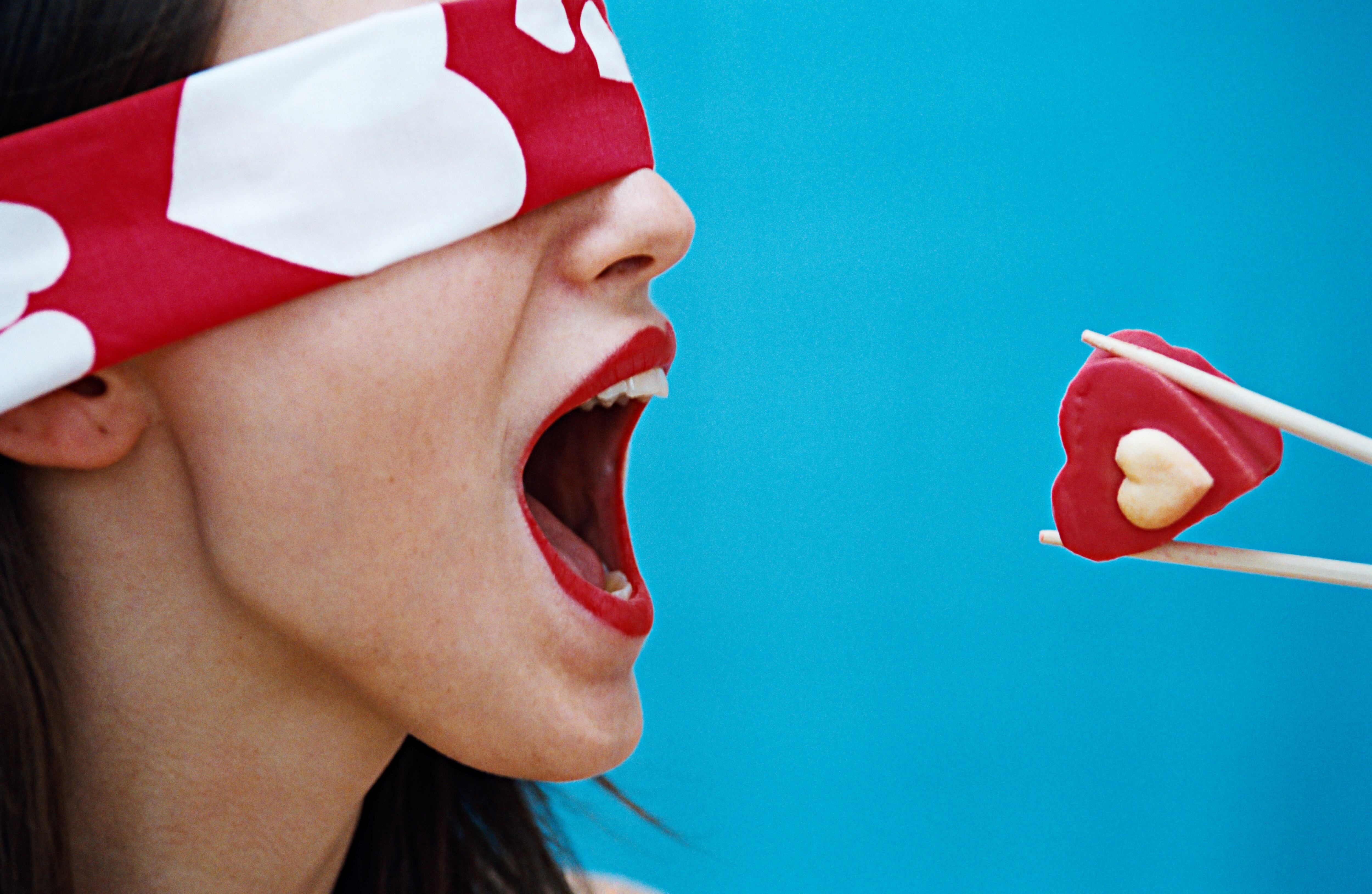 Woman being fed a red cupcake