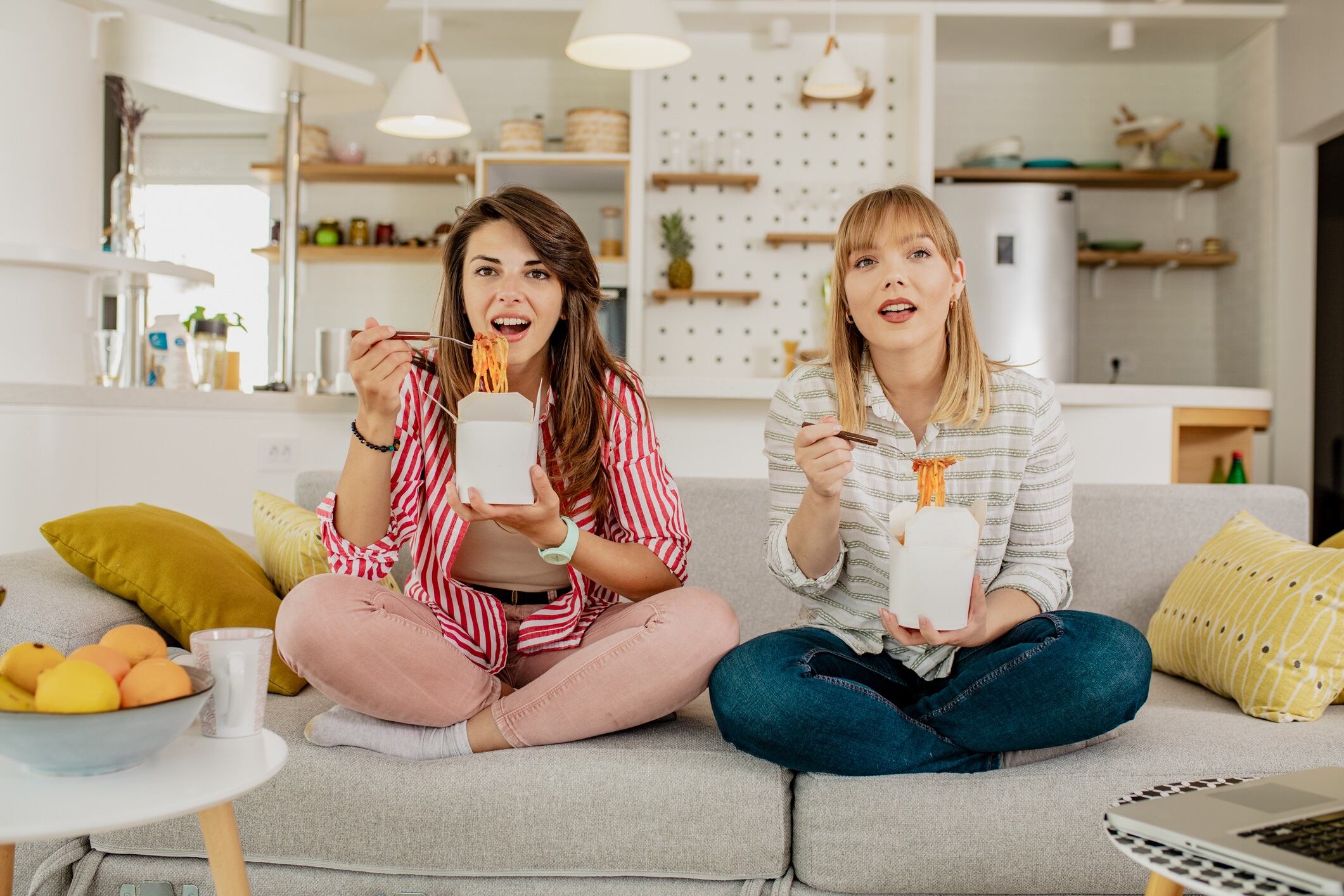 Friends eat pasta at home and watching a TV show