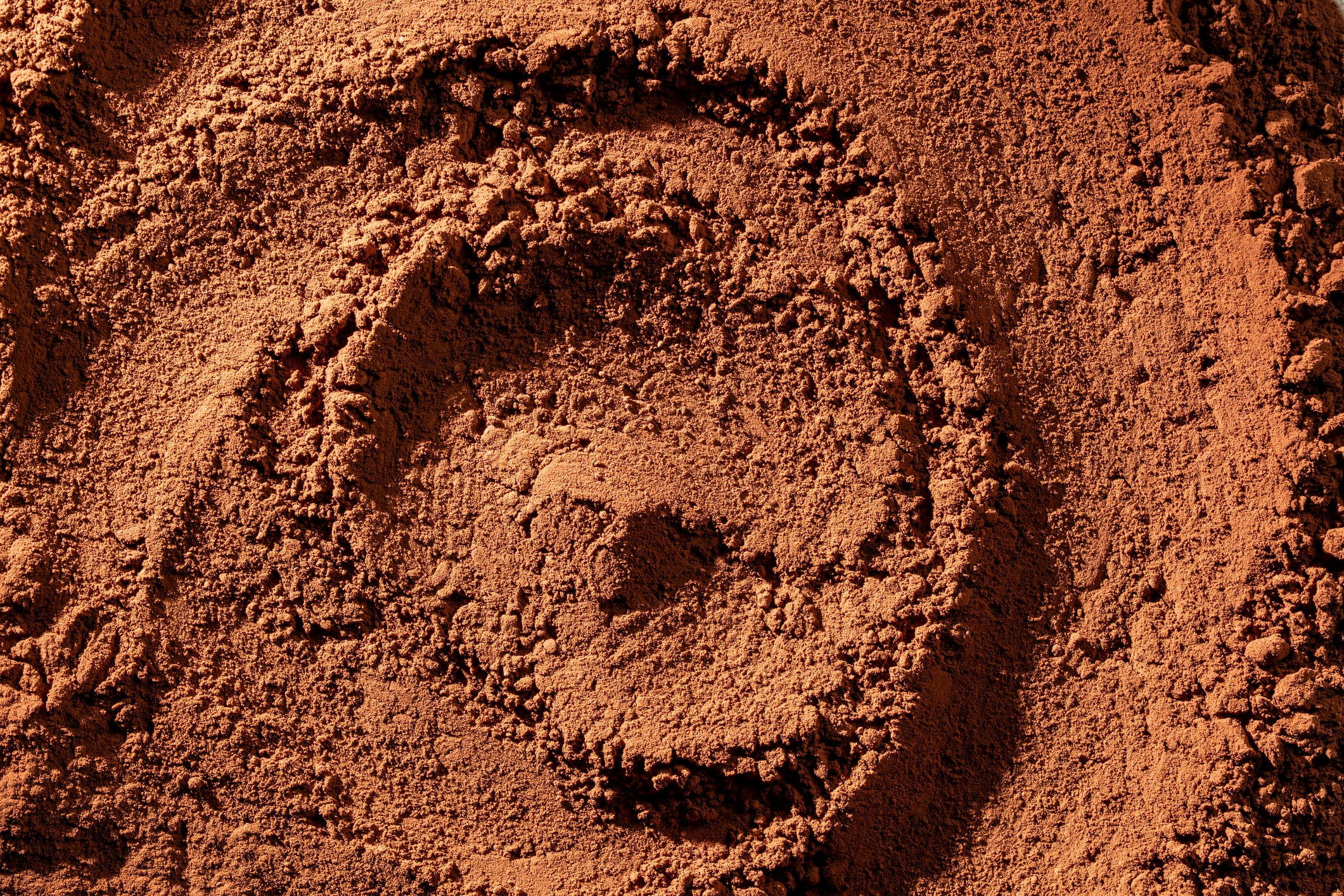 Natural dark brown cocoa powder textured background, close up