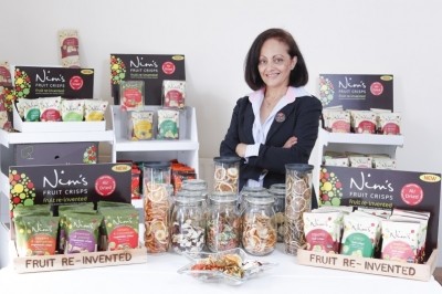 Nimisha Raja, founder of Nim's Fruit Crisps, with the company's products. Image courtesy of Nim's Fruit Crisps