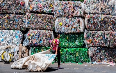 A worker works past crushed plastic bottles at a recycling plant in Costa Rica. © GettyImages/EzequielBecarra